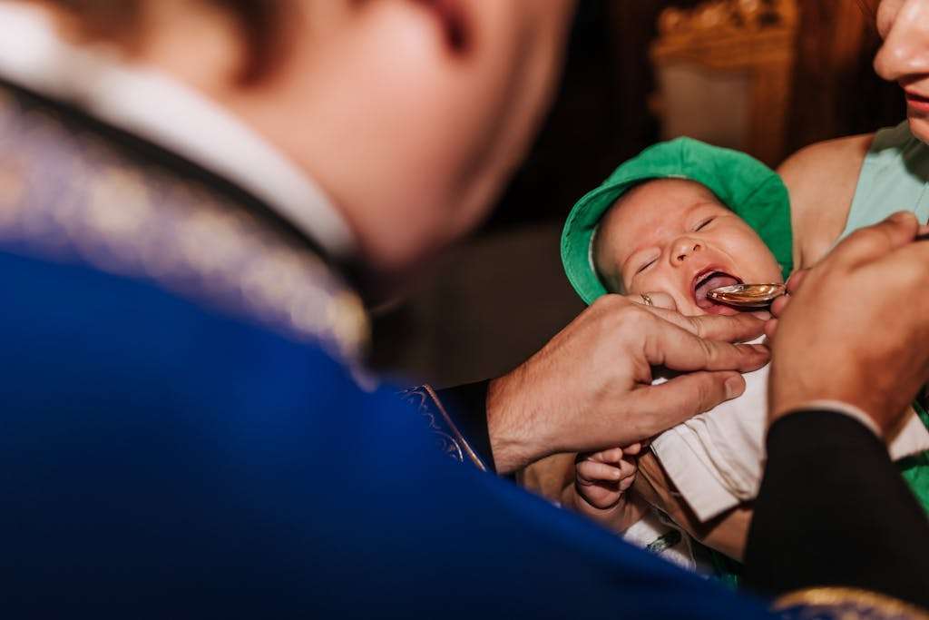 Newborn Baby Given a Spoon of Honey at a Ceremony